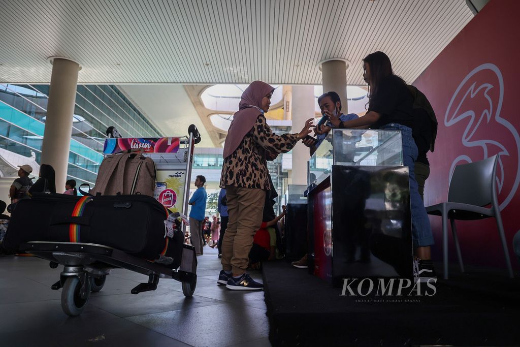 Pekerja migran Indonesia yang melakukan perjalanan mudik memberi kartu operator seluler ketika tiba di Bandara Internasional Yogyakarta, Kulon Progo, DI Yogyakarta, Senin (17/4/2023). 