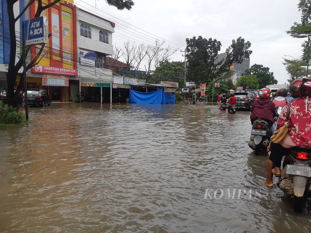 Banjir yang terjadi di Jalan R Soekamto, Palembang, Sumatera Selatan, Kamis (6/10/2022). Akibat pasang Sungai Musi dan cuaca ekstrem,  sejumlah titik di Kota Palembang terendam banjir. Kondisi ini sempat menghambat aktivitas warga.