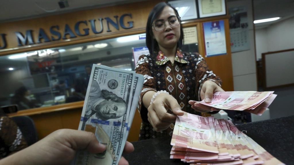 Petugas melayani penukaran dollar AS di tempat penukaran valuta asing PT Ayu Masagung, Jakarta Pusat, Jumat (9/11/2018).
