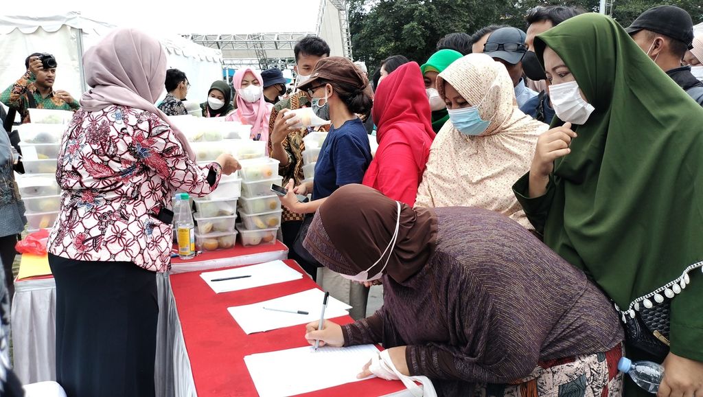 Warga antre pembagian kotak isi buah dari Festival Bunga dan Buah Nusantara 2022 di Alun-Alun Kota Bogor, Jawa Barat, Jumat (21/10/2022).