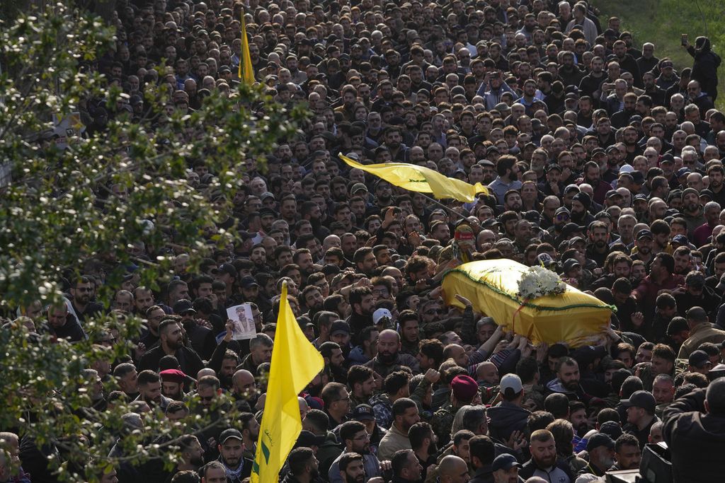 Para pelayat membawa peti mati komandan senior Hezbollah, Wissam Tawil, saat prosesi pemakamannya di Desa Khirbet Selm, Lebanon selatan, Selasa (9/1/2024). Tawil tewas dalam serangan udara Israel di Lebanon selatan.