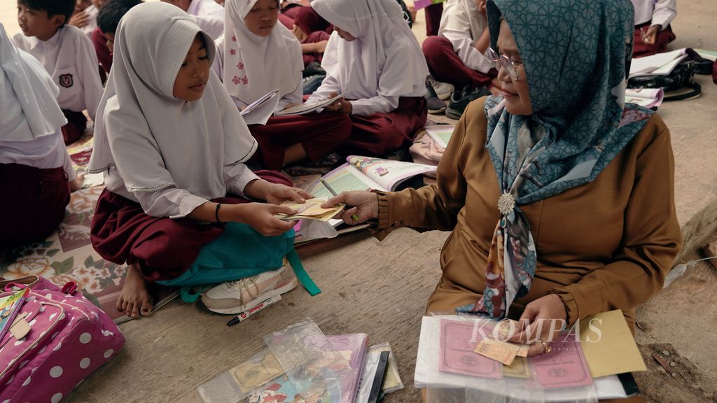 Seorang anak menabung setelah mengikuti pelajaran di halaman SDN Sukagalih, Kecamatan Cikalongkulon, Kabupaten Cianjur, Jawa Barat, akhir Agustus 20222. Anak-anak kelas IV, V, dan VII terpaksa belajar di luar ruang kelas secara bergantian sejak Juli 2022.
