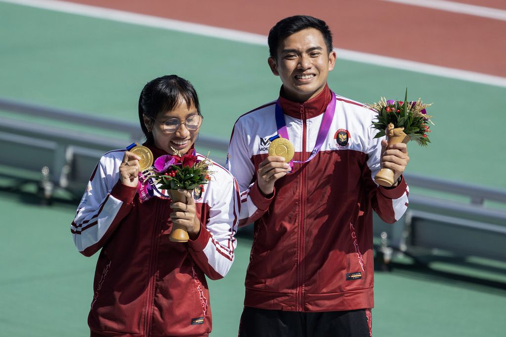 Ni Made Arianti Putri (kiri) memamerkan medali emas yang diarih dari nomor 100m T12 putri pada atletik Asian Para Games Hangzhou 2022 di Huanglong Sports Center Stadium, Selasa (24/10/2023). Arianti berhasil meraih medali emas dengan catatan waktu 12,52 detik. 