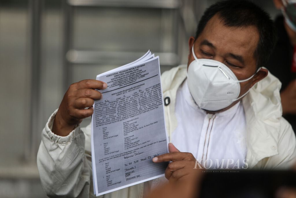 Koordinator Masyarakat Anti-Korupsi Indonesia (MAKI) Boyamin Saiman menunjukkan salinan dokumen kepada wartawan saat akan melapor dugaan penyimpangan penagihan pajak yang nilainya hingga Rp 1,7 triliun di Gedung Komisi Pemberantasan Korupsi, Jakarta, Maret 2021. 