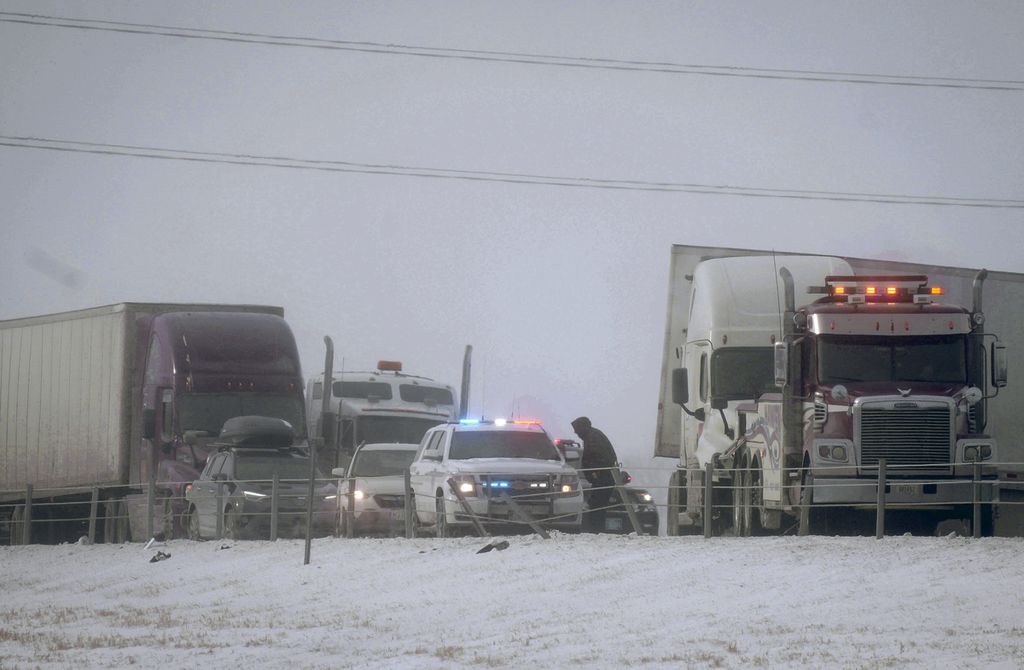 Petugas patroli jalan raya tengah di Iowa tengah menangani sebuah kecelakaan yang melibatkan beberapa kendaraan besar yang terjadi di Interstate 80, Des Moines barat, kamis (22/12/2022). Jalan yang tertutu salju membuat kendaraan menjadi sulit dikendalikan dan mudah terjadi kecelakaan. 