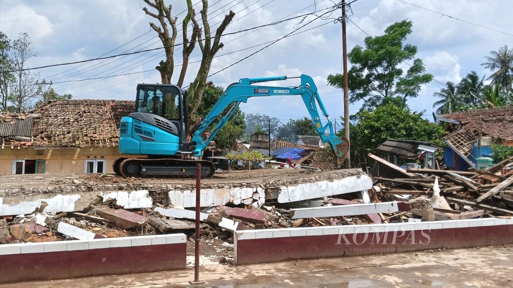 Alat berat digunakan untuk membersihkan areal SDN Sukamaju 1 dari puing-puing runtuhan sekolah yang terletak di Kampung Pangkalan, Desa Benjot, Kecamatan Cugenang, Cianjur, Kamis (8/12/2022).
