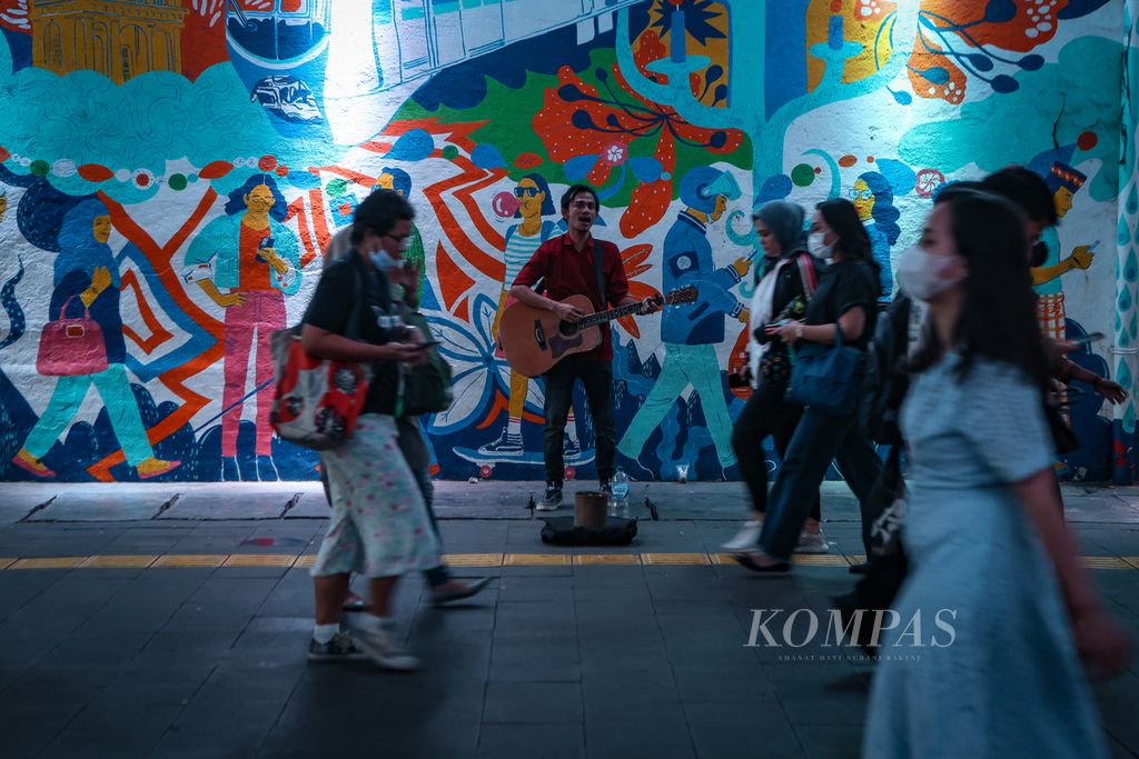Pengamen bernyanyi di antara lalu lalang warga di Terowongan Kendal, Jakarta, Jumat (8/12/2023). 