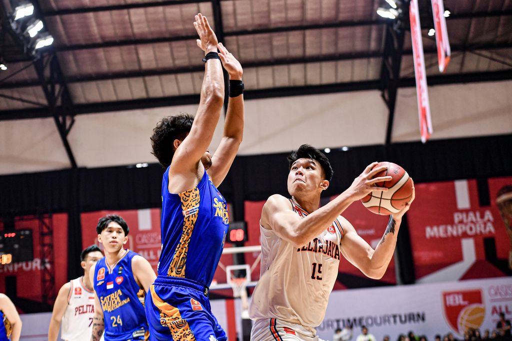 Center Pelita Jaya, Vincent Kosasih (memegang bola), mencari celah menembak bola ke keranjang Satria Muda dalam gim dua final All-Indonesian 2024 di Hall Basket Senayan, Jakarta, Sabtu (5/10/2024). Vincent menjadi penampil terbaik dalam laga itu dengan sumbangan 15 poin dan 6 <i>rebound</i>.