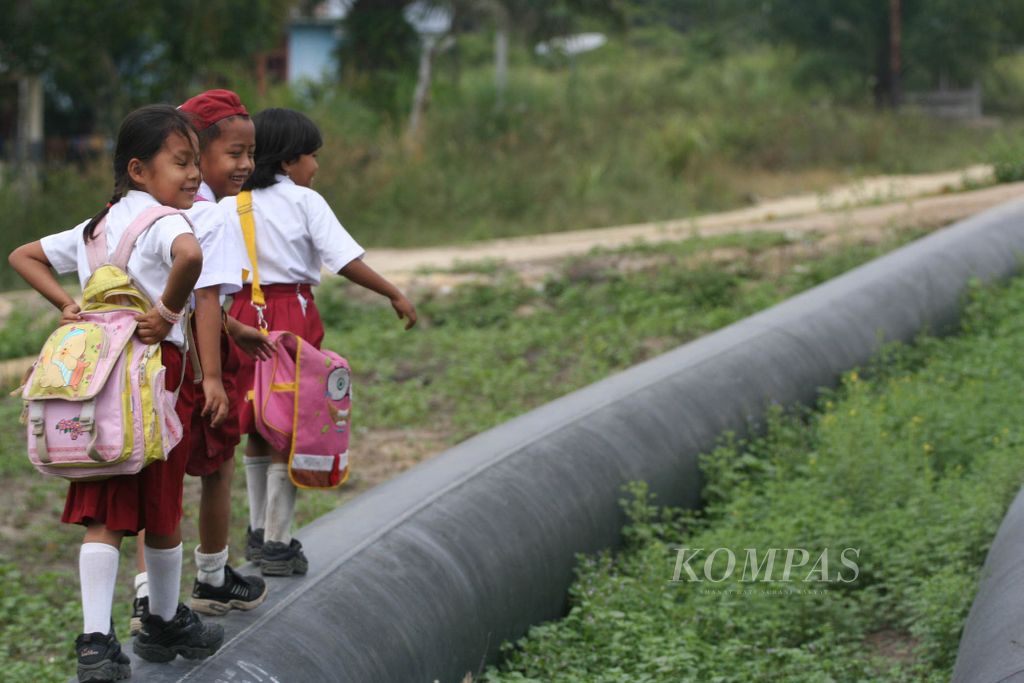 Provinsi Riau merupakan salah satu penghasil minyak terbesar di Indonesia, tetapi angka kemiskinan dan anak yang putus sekolah di daerah ini tergolong tinggi. Tiga anak ini berjalan meniti pipa minyak dan gas milik PT Chevron di Desa Kandis, Kecamatan Mandau, Riau, Selasa (27/3/2007).