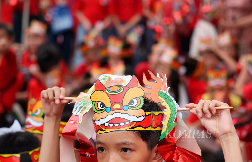 Anak-anak mengenakan hiasan kepala bergambar wajah barongsai saat turut merayakan Cap Go Meh di Graha Padma, Kota Semarang, Jawa Tengah, Jumat (23/2/2024). Cap Go Meh tersebut sebagai tradisi yang menandai berakhirnya rangkaian perayaan tahun baru Imlek. 