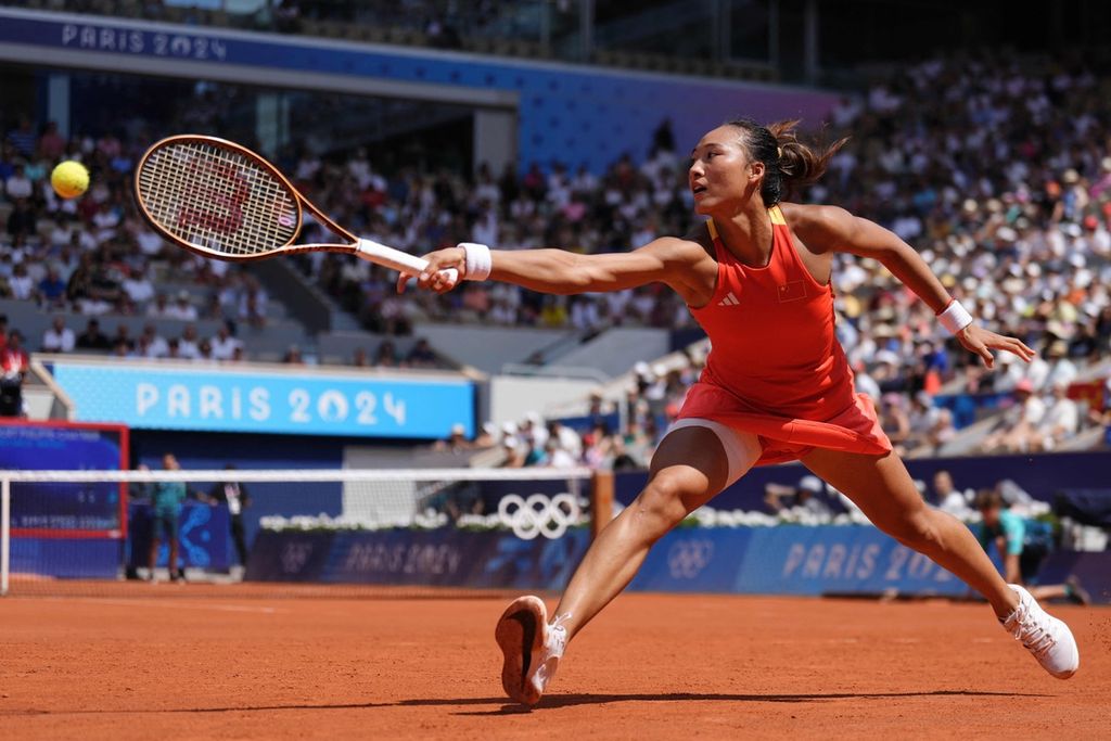 Petenis China, Zheng Qin Wen, mengembalikan bola ke petenis Polandia Iga Swiatek pada semifinal tungal putri Olimpiade Paris 2024 di Roland Garros, Paris, Perancis, Kamis (1/8/2024). Zheng menang dengan skor 6-2, 7-5.