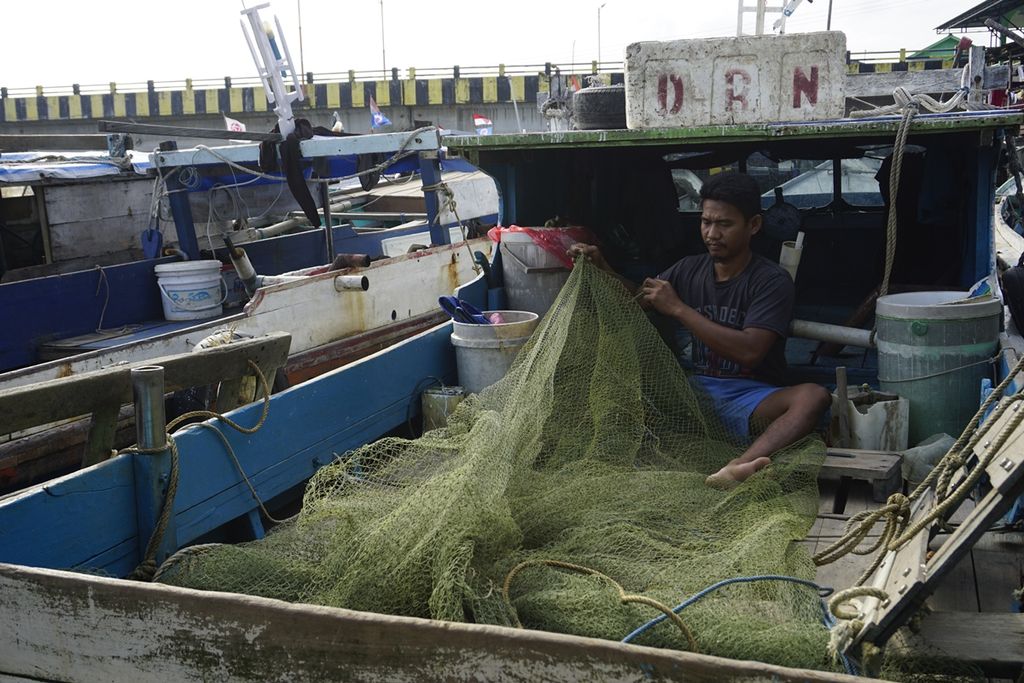 Seorang nelayan tengah memperbaiki jaring di kampung nelayan Pantai Manggar, Balikpapan, Kalimantan Timur, Selasa (29/10/2019).