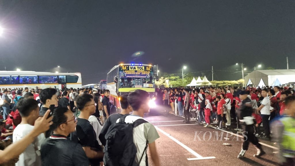 Penonton menunggu <i>shuttle bus</i> seusai menyaksikan laga pembuka Piala Dunia U-17 2023 di Stadion Gelora Bung Tomo, Surabaya, Jawa Timur, Jumat (10/11/2023) malam. Mereka menunggu sampai larut malam untuk naik bus.