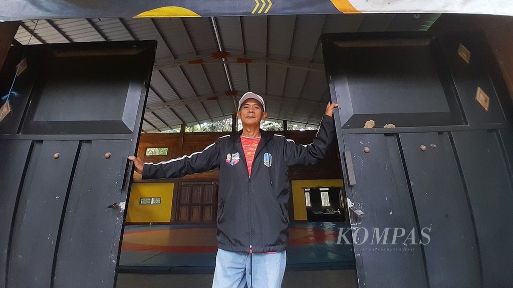 Sulastiman (62) berada di pintu GOR yang dia dirikan di Desa Tulusbesar, Kecamatan Tumpang, Kabupaten Malang, Jawa Timur, Rabu (17/1/2024).