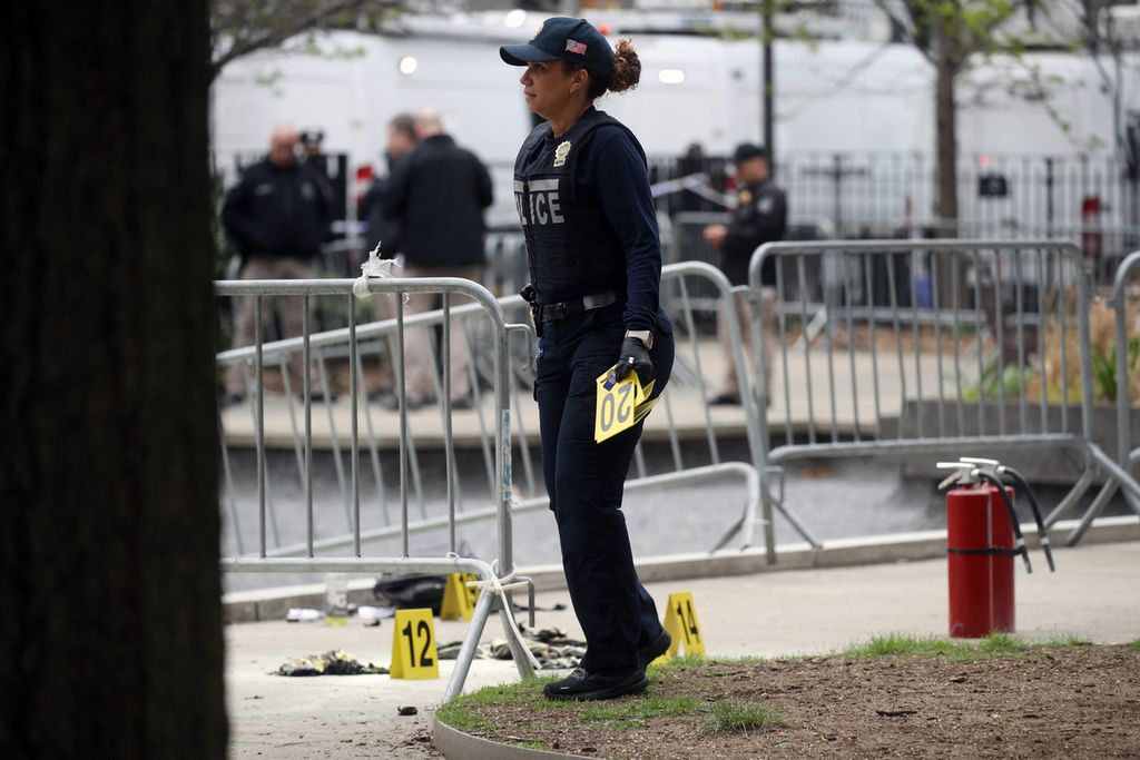 New York police officers gathered evidence around a park outside the Manhattan Criminal Court in New York City, USA, where a man set himself on fire on Friday (4/19/2024) local time. The court is the location of the trial involving the hush money case of former President Donald Trump.