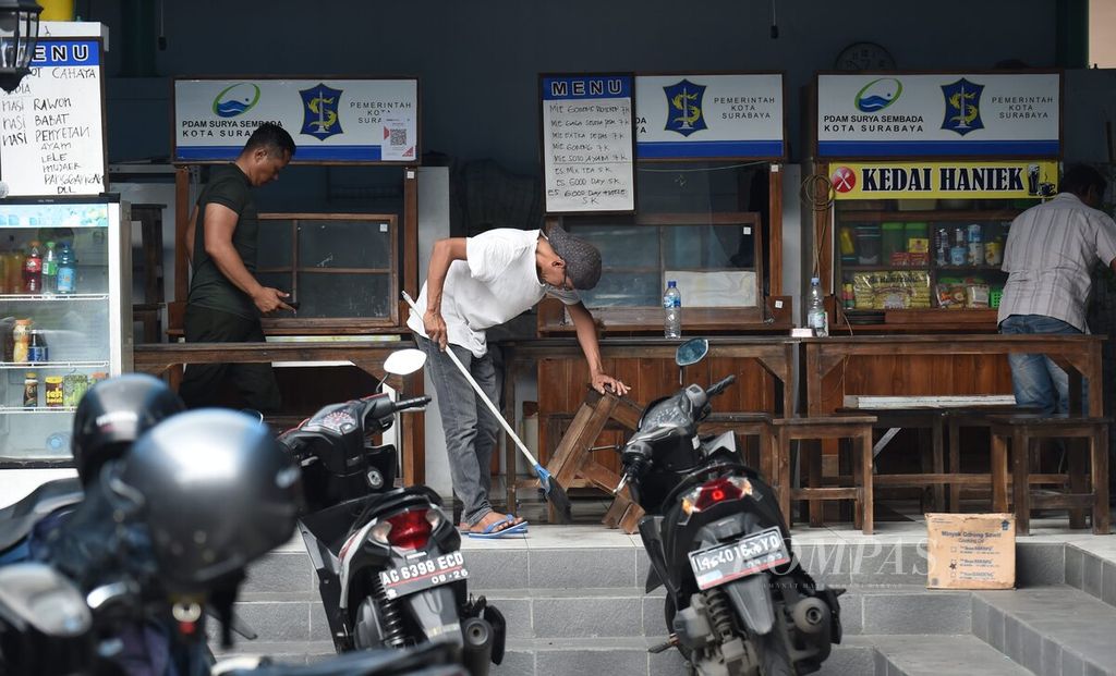 Pemilik membersihkan warungnya pascaledakan di markas Detasemen Gegana Satuan Brimob Polda Jawa Timur di Jalan Gresik, Surabaya, Senin (4/3/2024). 