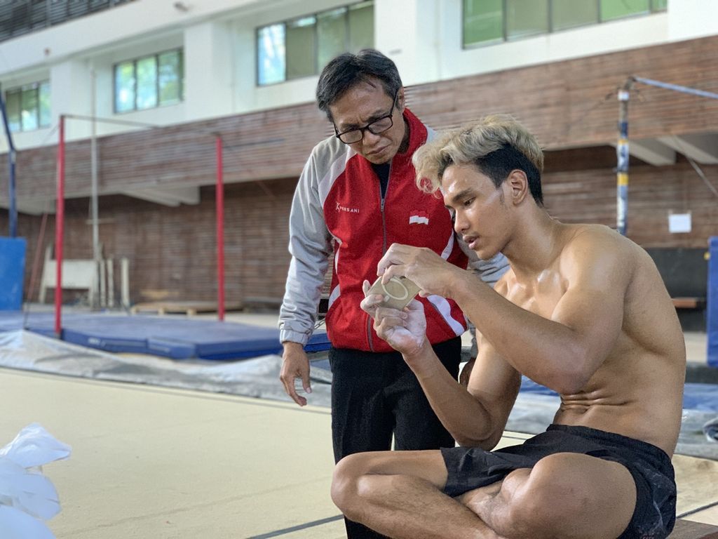 Pelatih senam nasional, Jonathan Sianturi (kiri), berdiskusi dengan Abiyuraffi pada sesi latihan pelatnas senam SEA Games Kamboja 2023 di GOR Senam Radin Inten, Jakarta, Selasa (29/11/2022).