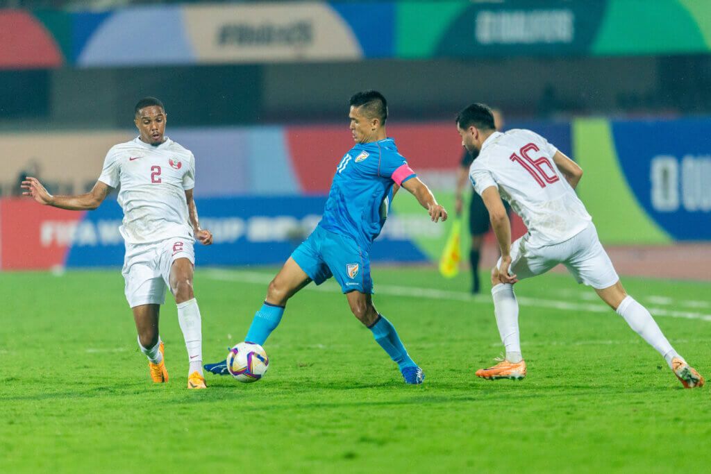 Kapten India, Sunil Chhetri, mengontrol bola di tengah kawalan dua pemain Qatar pada laga kualifikasi Piala Dunia 2026, 21 November 2023, di Stadion Kalinga, India. Chhetri jadi andalan India untuk bersaing di Piala Asia 2023.