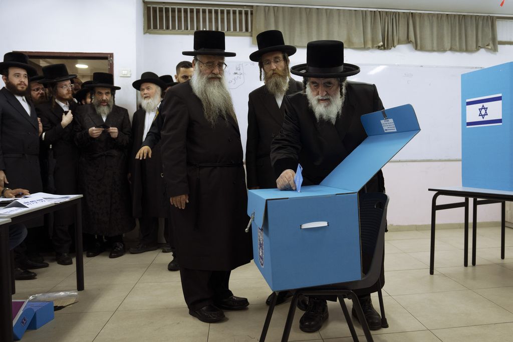 Kelompok ultra ortodoks Yahudi mengamati Rabbi Israel, Haeger, memasukkan surat suara ke kotak suara pada Pemilu Israel, Selasa (1/11/2022). Hasil jajak pendapat memperlihatkan Likud bersama sejumlah partai sayap kanan diprediksi memenangi pemilihan. 