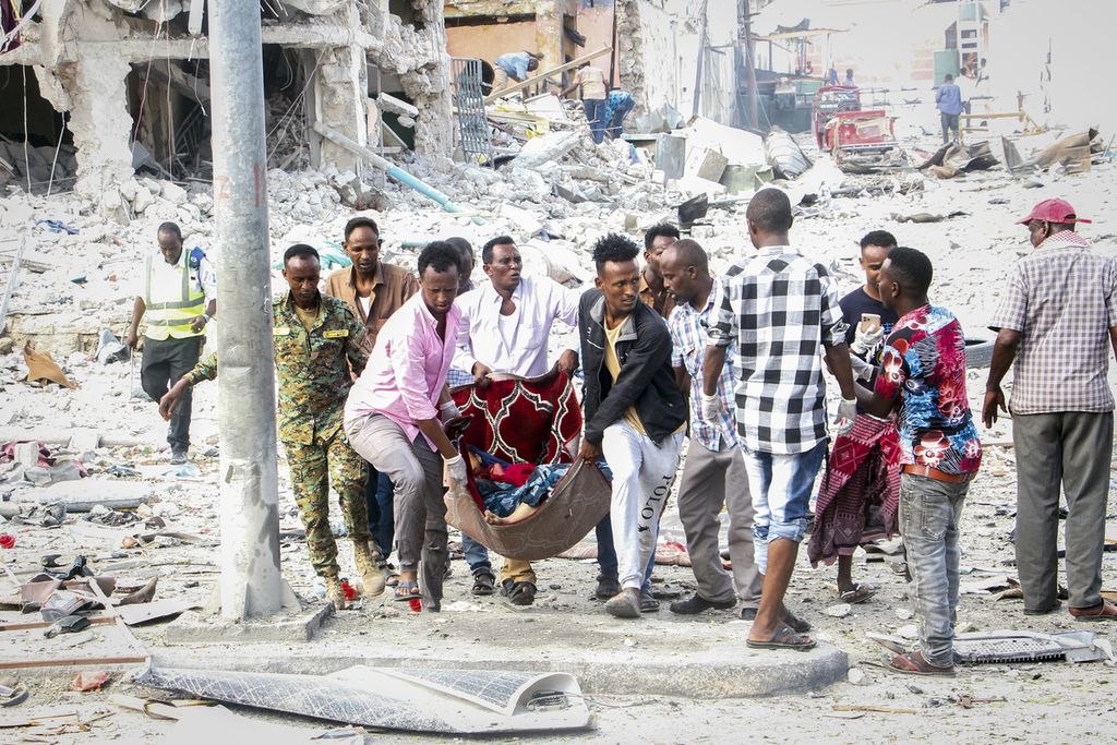 Warga dan relawan penyelamat tengah memindahkan warga yang mengalami luka berat setelah dua bom mobil meledak dan mengguncang Ibu Kota Somalia Mogadishu, Sabtu (29/10/2022). Serangan bom mobil ini menewaskan 100 orang dan melukai 300 orang. Kelompok teror Al Shahab menyatakan bertanggung jawab atas serangan tersebut. 