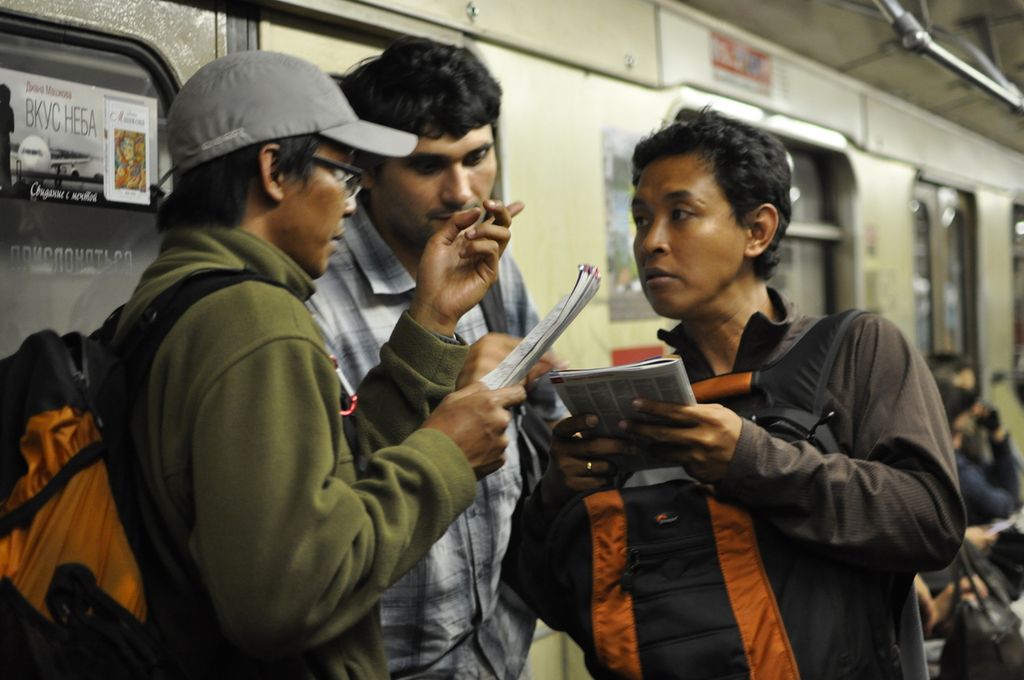 Fajri Al Lutfi dari Tim Ekspedisi Tujuh Puncak Dunia Wanadri (kiri) dan wartawan <i>Kompas</i> Ambrosius Harto membicarakan rute atau jaringan layanan kereta bawah tanah dalam perjalanan dengan moda transportasi umum itu, pada 23 Agustus 2010.