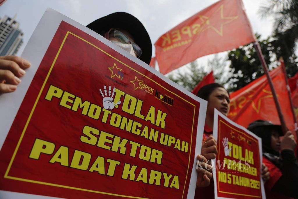 Buruh industri padat karya berunjuk rasa di depan Gedung Kementerian Ketenagakerjaan, Jakarta, Selasa (23/5/2023). Mereka menuntut Menteri Ketenagakerjaan Ida Fauziyah mencabut Permenaker No 5 Tahun 2023 yang melegalkan pemotongan upah buruh hingga 25 persen. 