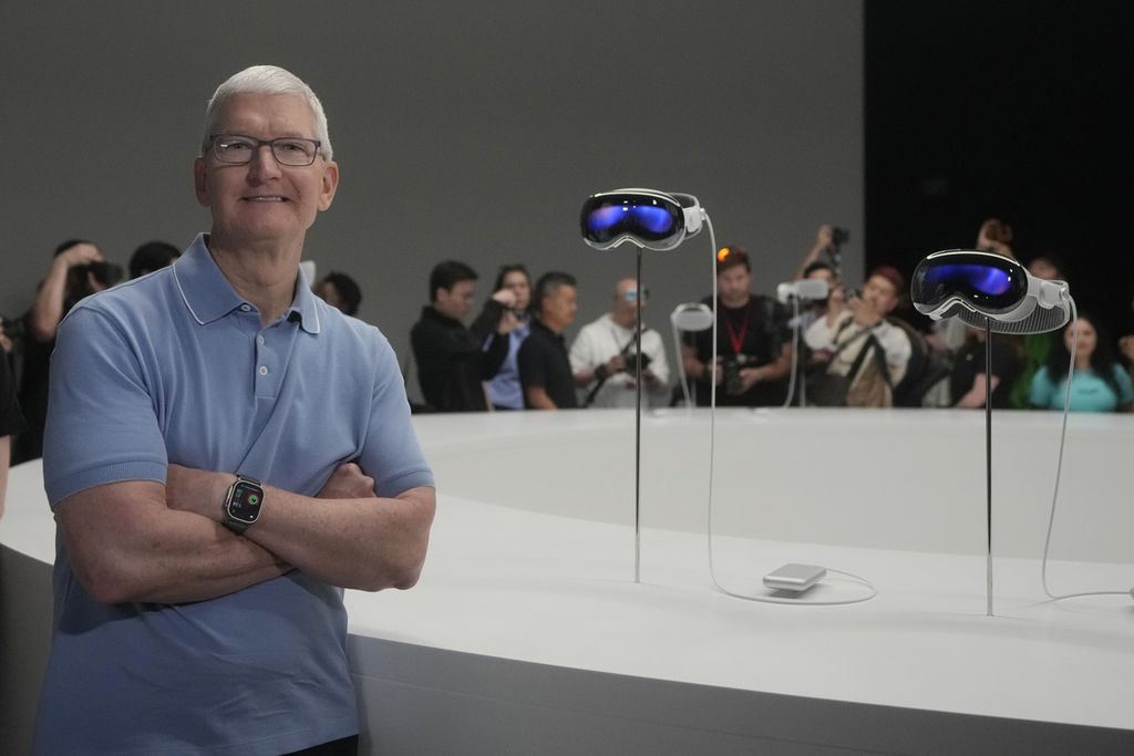 CEO Apple TIm Cook berpose di depan gawai baru Apple, Apple Vision Pro, yang dipajang di Kampus Apple, Cupertino, California, Jumat (2/2/2024).
