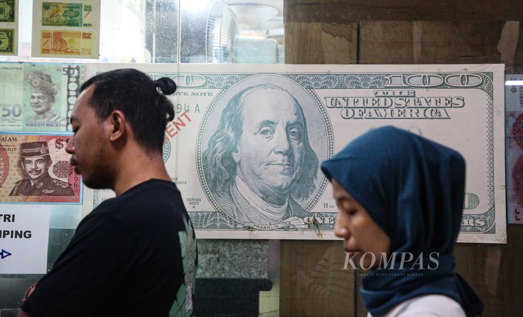 Visitors queue at PT Valuta Artha Mas foreign exchange counter in Jakarta, on Tuesday (16/4/2024). The weakening rupiah is being taken advantage of by the public to exchange their US dollars.