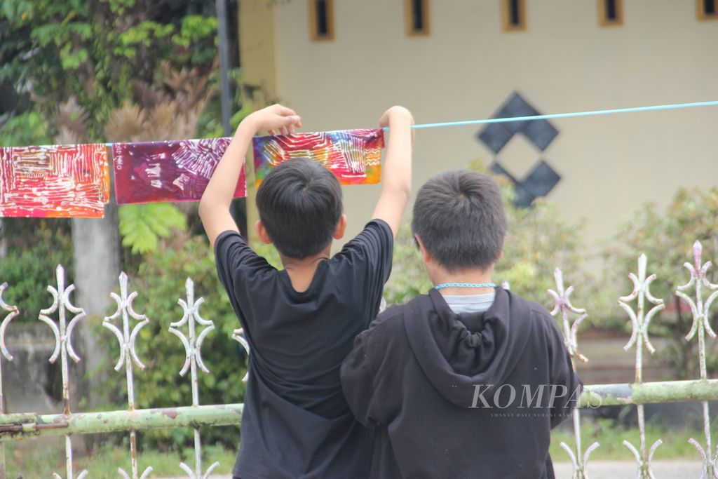 Anak-anak di Kota Singkawang, Kalimantan Barat, sedang menjemur batik hasil karyanya, Sabtu (25/6/2022).