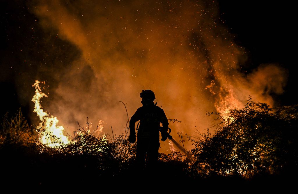 Seorang petugas pemadam kebakaran mencoba memadamkan api yang melanda hutan di sekitar Desa Eiriz di Baiao, Portugal utara, 15 Juli 2022. 