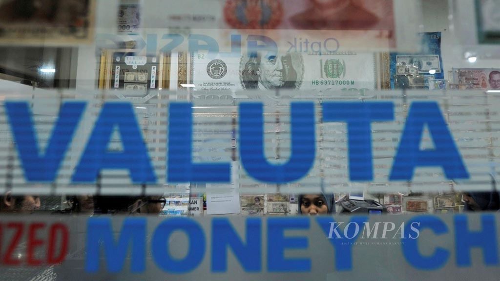 Pramuniaga melayani konsumen yang akan menukarkan uang di salah satu money changer di Jakarta
