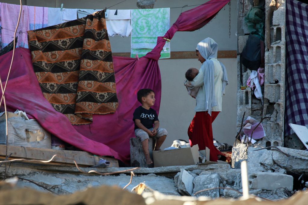 Warga Palestina mengungsi di bangunan yang rusak akibat gempuran Israel, di Bani Suhayla, di Jalur Gaza selatan, 17 Juli 2024. 