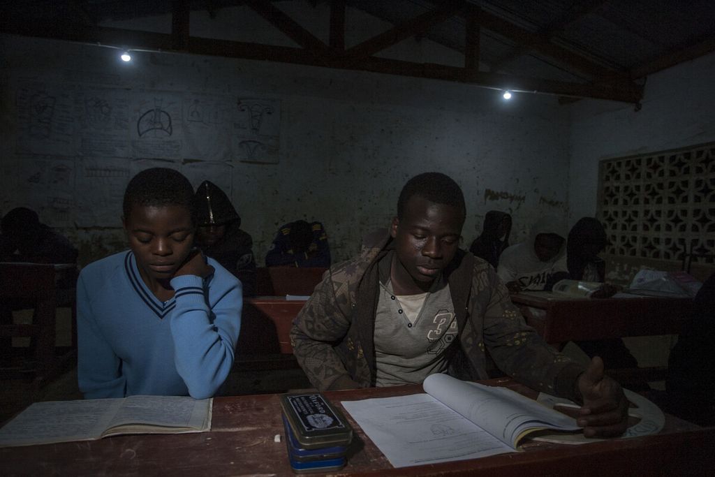 Siswa menghadiri kelas malam untuk belajar di Sekolah Dasar Kasangazi dekat desa Yobe Nkosi, Malawi utara yang merupakan penerima manfaat listrik yang dihasilkan oleh mantan siswa Colrerd Nkosi yang merancang turbin bertenaga air di daerahnya, Senin (23/8/2021).