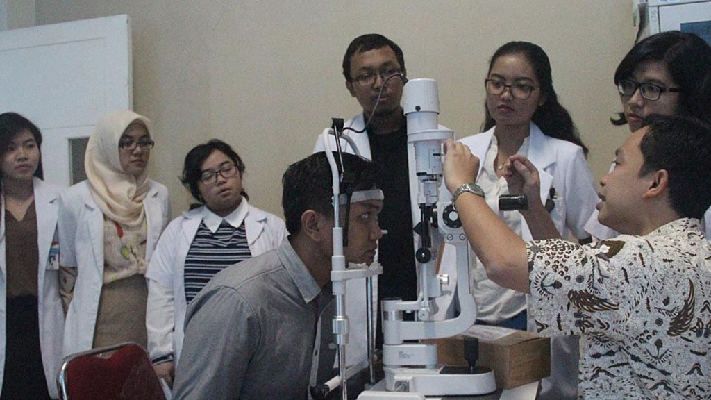 Muhammad Asroruddin, dokter spesialis mata di Rumah Sakit Universitas Tanjungpura, Pontianak (baju batik), membimbing koasistensi sarjana kedokteran FK Untan, Senin (2/5/2015), di Pontianak. Koasistensi merupakan program pendidikan profesi yang harus ditempuh calon dokter setelah menyelesaikan program akademik. 