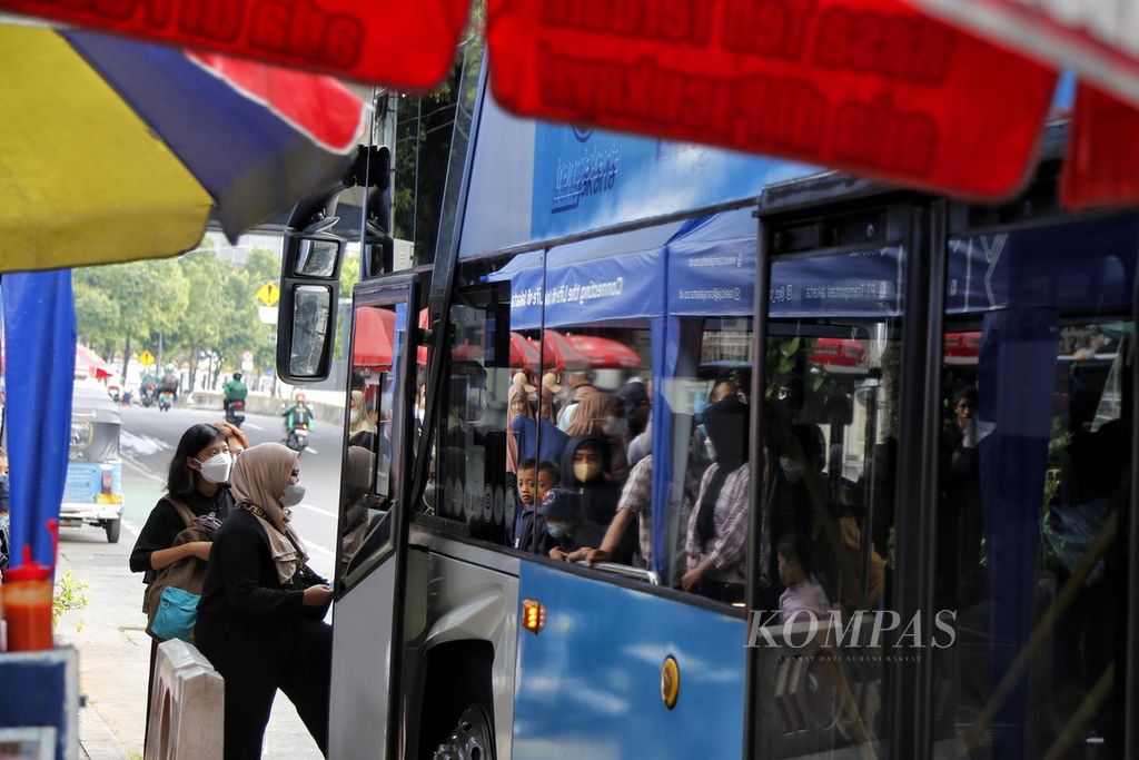 Antrean panjang warga terpantul dari kaca jendela saat akan menaiki bus tingkat wisata Transjakarta untuk berkeliling kota di Halte Masjid Istiqlal, Jalan Juanda, Jakarta, Minggu (2/7/2023).
