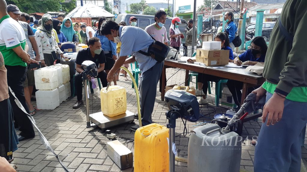 Ratusan pedagang di Pasar Larangan, Sidoarjo, mengantre pembelian minyak goreng curah dalam operasi pasar yang digelar Kementerian Perdagangan, Selasa (22/1/2022).