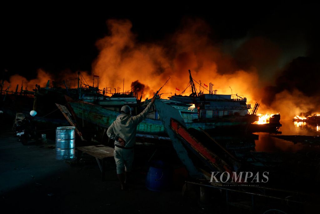 Warga menyaksikan sejumlah kapal nelayan yang terbakar di Pelabuhan Perikanan Pantai Tegalsari, Kota Tegal, Jawa Tengah, Selasa (15/8/2023). 