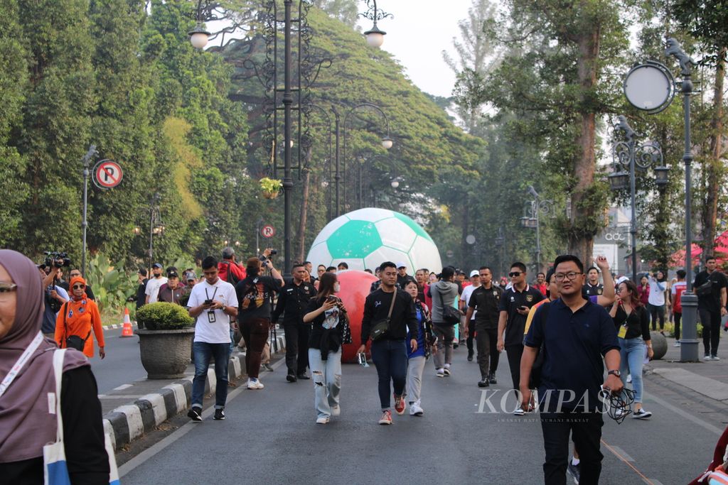 Sejumlah warga menggiring bola raksasa dalam rangkaian acara Trophy Experience Piala Dunia U-17 2023 Car Free Day Dago di ruas Jalan Ir H Juanda, Kota Bandung, Jawa Barat, Minggu (22/10/2023).