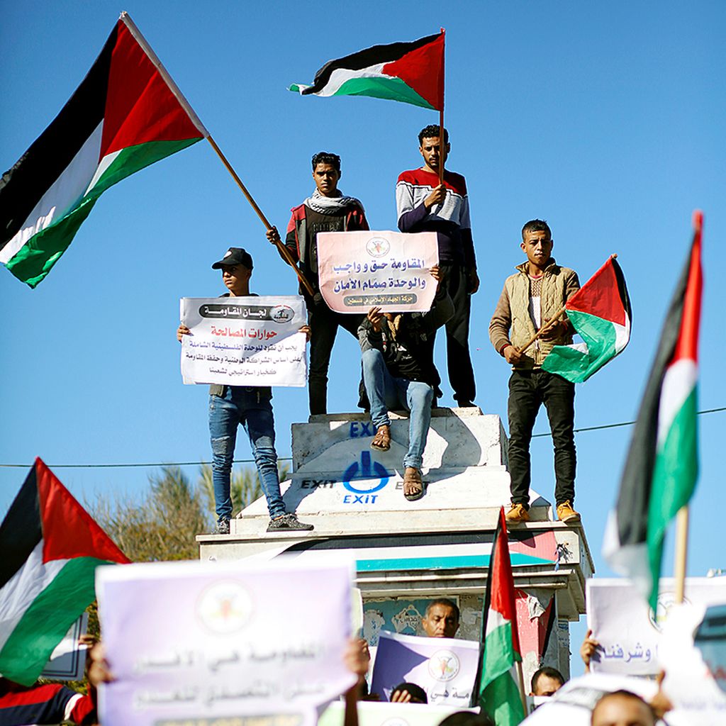 Warga Palestina  mengibarkan bendara nasional mereka dalam sebuah unjuk rasa di Kota Gaza, Minggu (3/12), untuk mendukung perundingan rekonsiliasi antara Hamas dan Fatah.