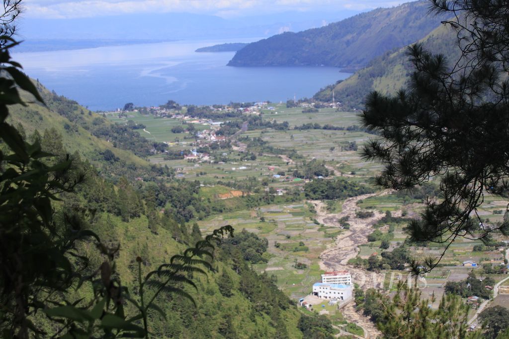Lanskap Lembah Bakkara tampak dari ketinggian di Kecamatan Baktiraja, Kabupaten Humbang Hasundutan, Sumatera Utara, Jumat (8/12/2023). Pembalakan liar yang semakin marak membuat permukiman di bawah bukit itu rawan bencana.