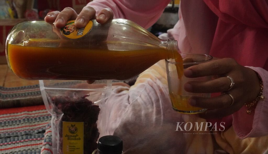 Pembuat jamu di Desa Simbangdesa, Kecamatan Tulis, Kabupaten Batang, Jateng, menuangkan jamu kunyit asam ke dalam gelas, Jumat (8/11/2019). Jamu tersebut diberi merek Jamoe Simbok karena jamu tersebut dibuat oleh ibu-ibu yang dalam bahasa Jawa disebut simbok-simbok.