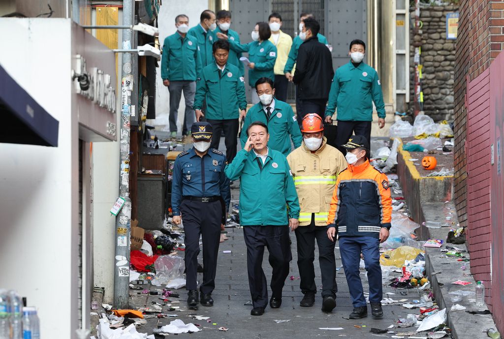 Presiden Korea Selatan Yoon Suk-yeol (depan, ke-2 dari kiri) mengunjungi lokasi insiden mematikan saat pesta Halloween di Distrik Itaewon di Seoul, Minggu (30/10/2022).