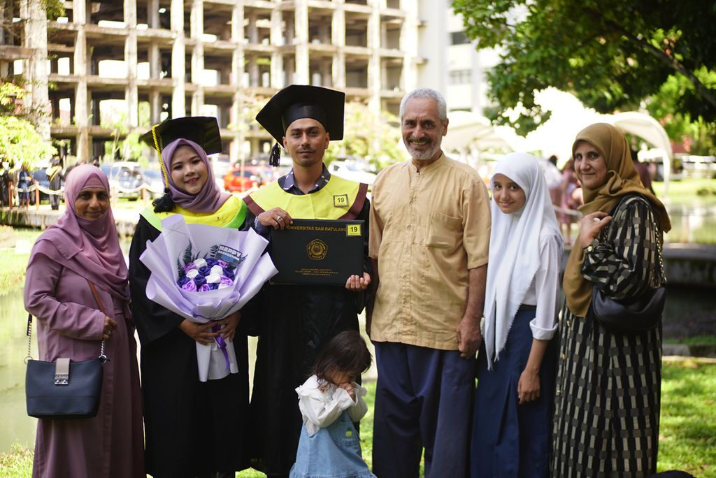 Keluarga Ali, dari kiri: Amira Mustafa (51, ibu), Audina Givethee (25, ipar), Amar (30, kakak), Adella (2, keponakan), M Yaqub M Karim (61, paman), Tahanan PBB II alias Sakinah (12, adik sepupu), dan Aqila Douraiyah (51, bibi). Mereka berpose bersama pascawisuda Amar dan Audina di Universitas Sam Ratulangi, 9 Februari 2023.