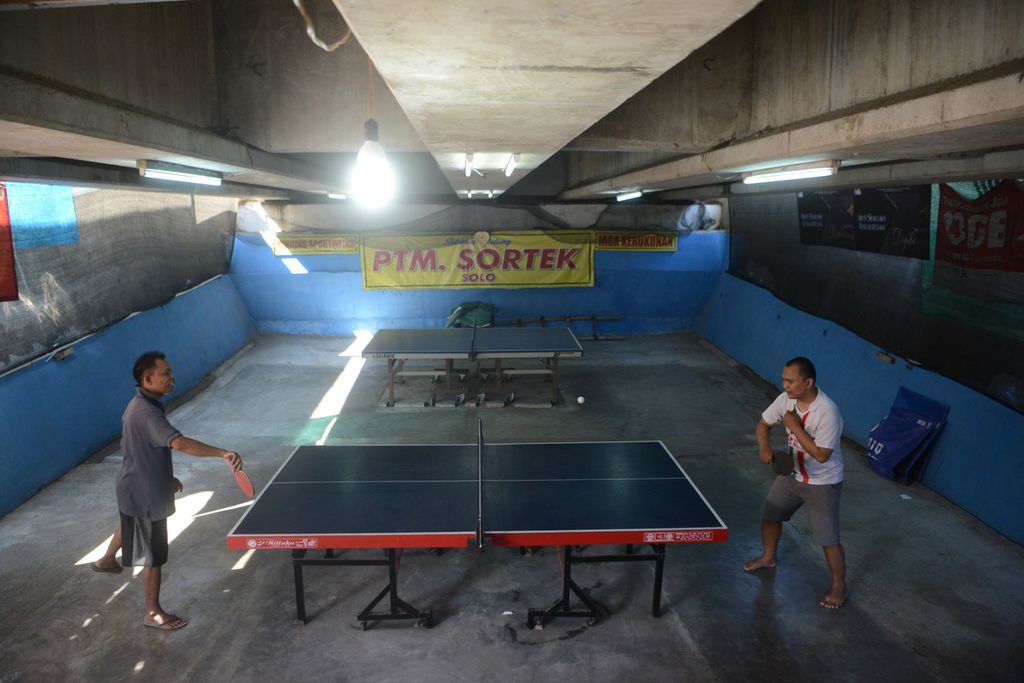Warga bermain tenis meja di bawah Jembatan Kreteg Abang di Kelurahan Gilingan, Banjarsari, Solo, Jawa Tengah, Senin (17/8/2020). Setelah dibersihkan, area di bawah jembatan itu kini dapat dimanfaatkan menjadi ruang publik bagi warga di tepi Kali Anyar tersebut. 