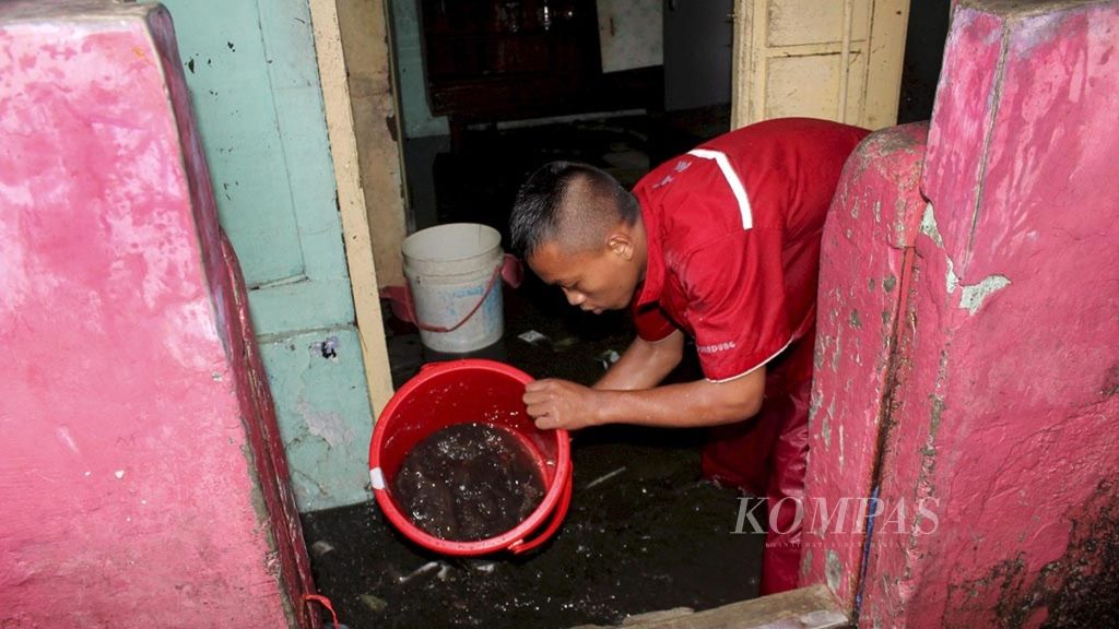 Petugas Palang Merah Indonesia membantu membersihkan rumah warga setelah diterjang banjir setinggi 1,5 meter, akhir 2018.