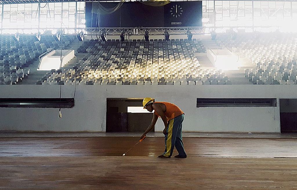 Seorang pekerja sedang mengerjakan tahap akhir  lantai kayu arena di Istora Senayan, Jakarta Pusat, Sabtu (23/9). Proyek pembangunan Istora Senayan ini telah mencapai 92 persen dan ditargetkan selesai pada 8 November.