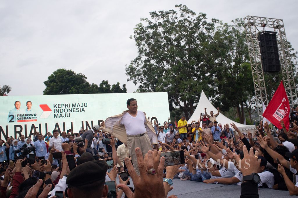 Calon presiden Prabowo Subianto melepas kemeja dan melemparkannya ke pendukung yang berkumpul saat acara Silaturahmi Relawan Prabowo Subianto di halaman Stadion Tumenggung Abdul Jamal, Batam, Kepulauan Riau, Sabtu (13/1/2024).