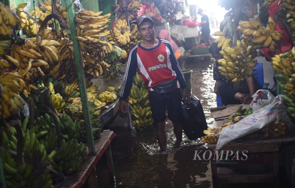 Pedagang air di Pasar Wadungasri, Kecamatan Waru, Sidoarjo, yang tergenang banjir, Rabu (7/2/2024). 