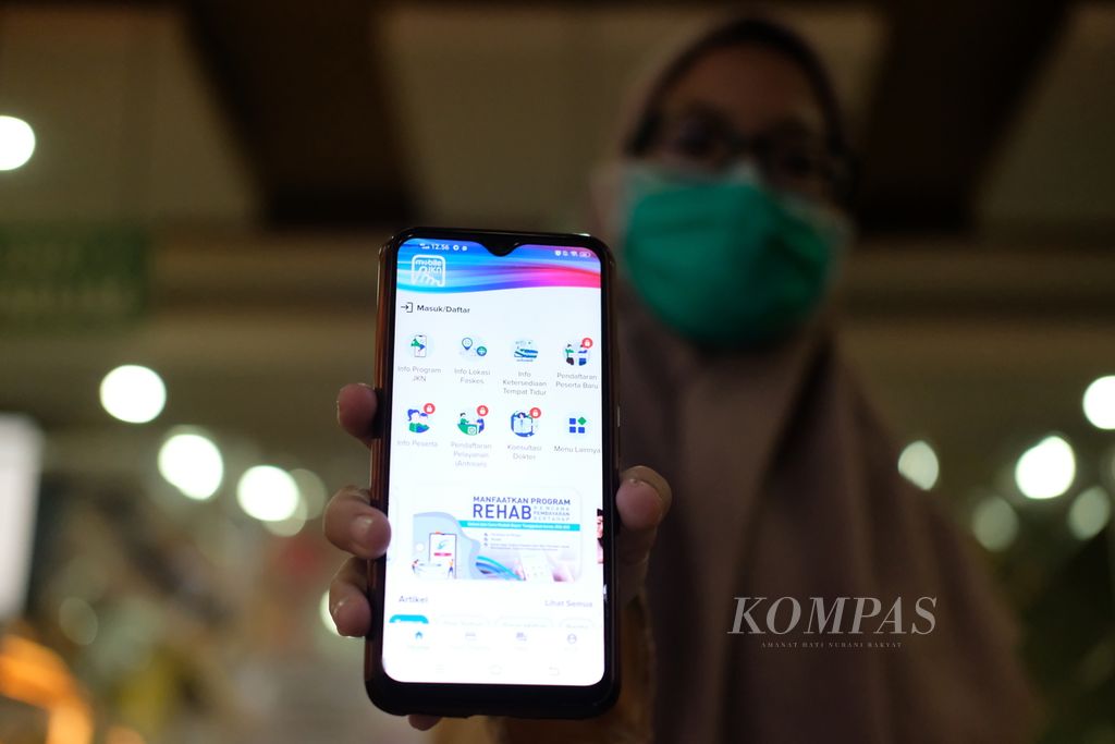 Warga memperlihatkan aplikasi Jaminan Kesehatan Nasional di Puskesmas Kecamatan Palmerah, Jakarta Barat, Jumat (21/10/2022).