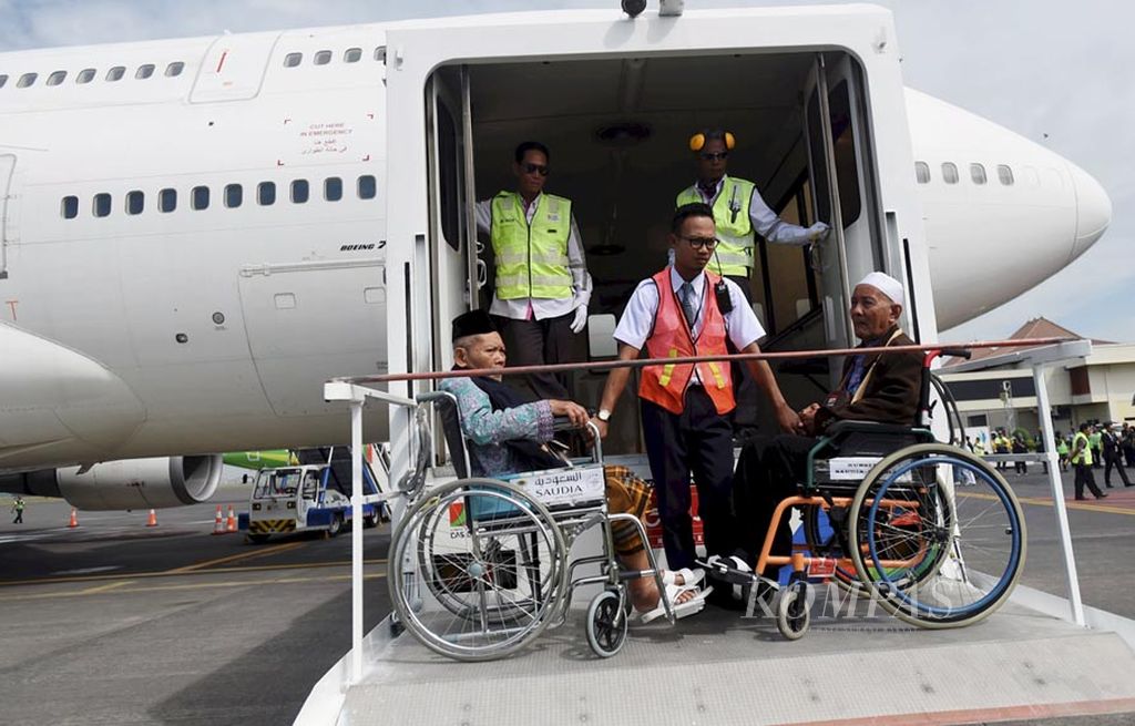 Petugas  membantu  jemaah  haji kloter pertama Embarkasi Surabaya yang kesulitan berjalan dengan menaiki lift khusus untuk masuk ke pesawat Saudi Arabian Airlines  di Bandara Juanda, Sidoarjo, Jawa Timur, Jumat (28/7). Dalam kelompok terbang tersebut terdapat 445 anggota jemaah   haji.